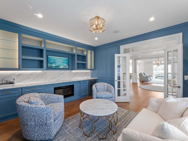 Modern blue living room in Bucks County, PA with fireplace, loveseat, and two chairs.
