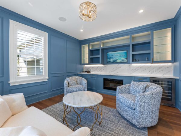 Modern blue sitting room in Bucks County with fireplace, loveseat, and two chairs.