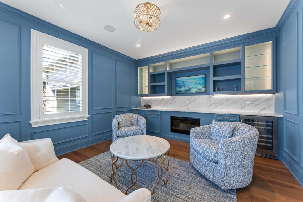 Modern blue sitting room in Montgomery County with fireplace, loveseat, and two chairs.