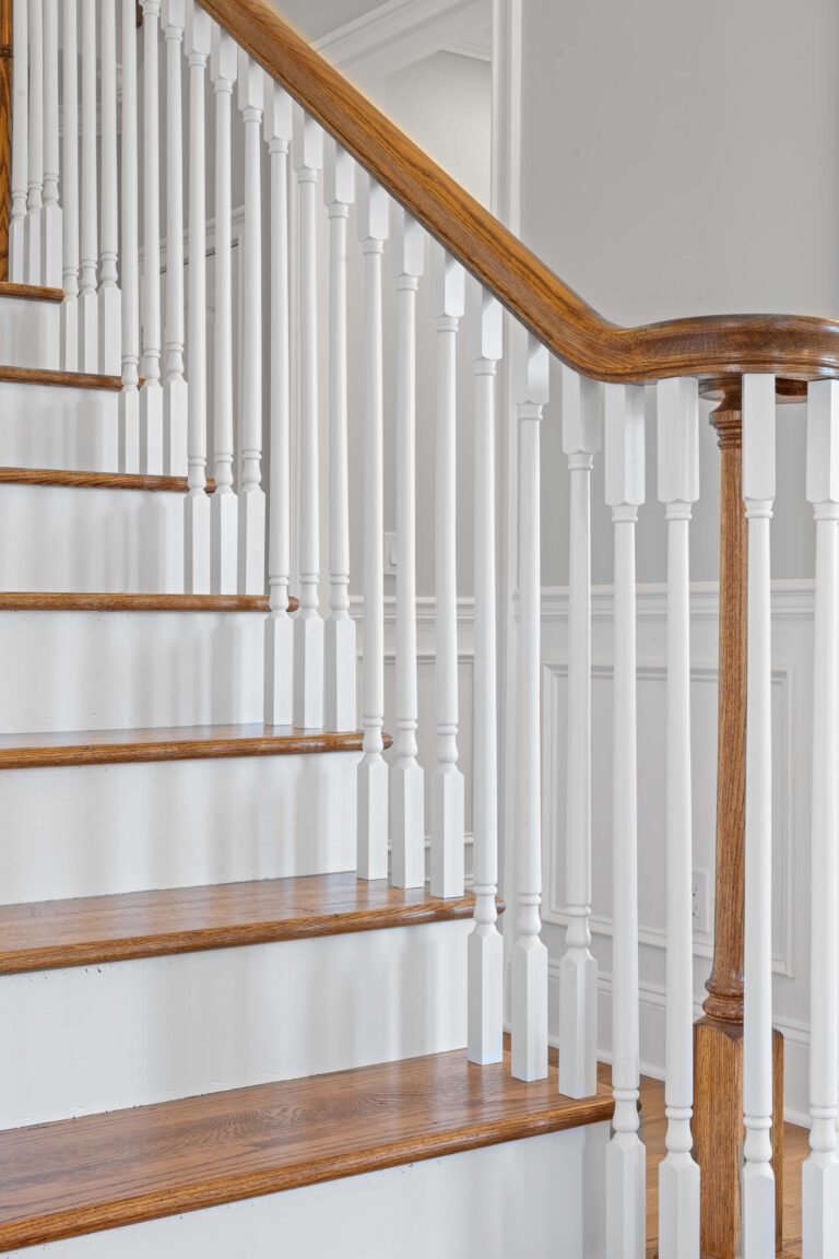 Modern staircase in Bucks County, PA with wood steps and railing, white rods.