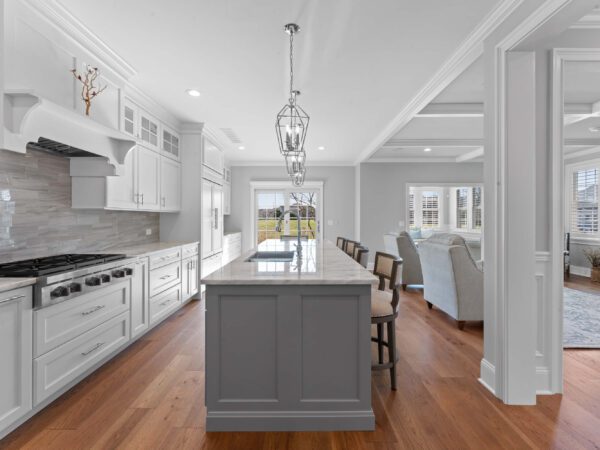 Modern kitchen in Bucks County, PA with light grey walls, marble countertops, stovetop, and island.
